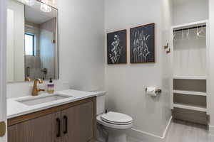 Full bath with a spacious closet, vanity, a shower stall, and light wood-type flooring