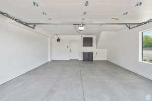 Garage with baseboards and a garage door opener