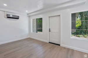 Foyer entrance featuring wood finished floors, recessed lighting, and an AC wall unit