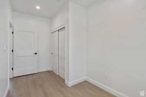 Hall featuring light wood finished floors and recessed lighting