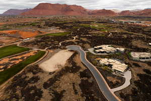 Aerial view of property and surrounding area with a mountain backdrop and a golf course