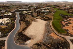 Aerial view of property's location featuring a mountain backdrop, nearby suburban area, and a local golf course