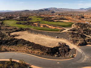 Aerial view of property and surrounding area featuring a mountain backdrop and a local golf course