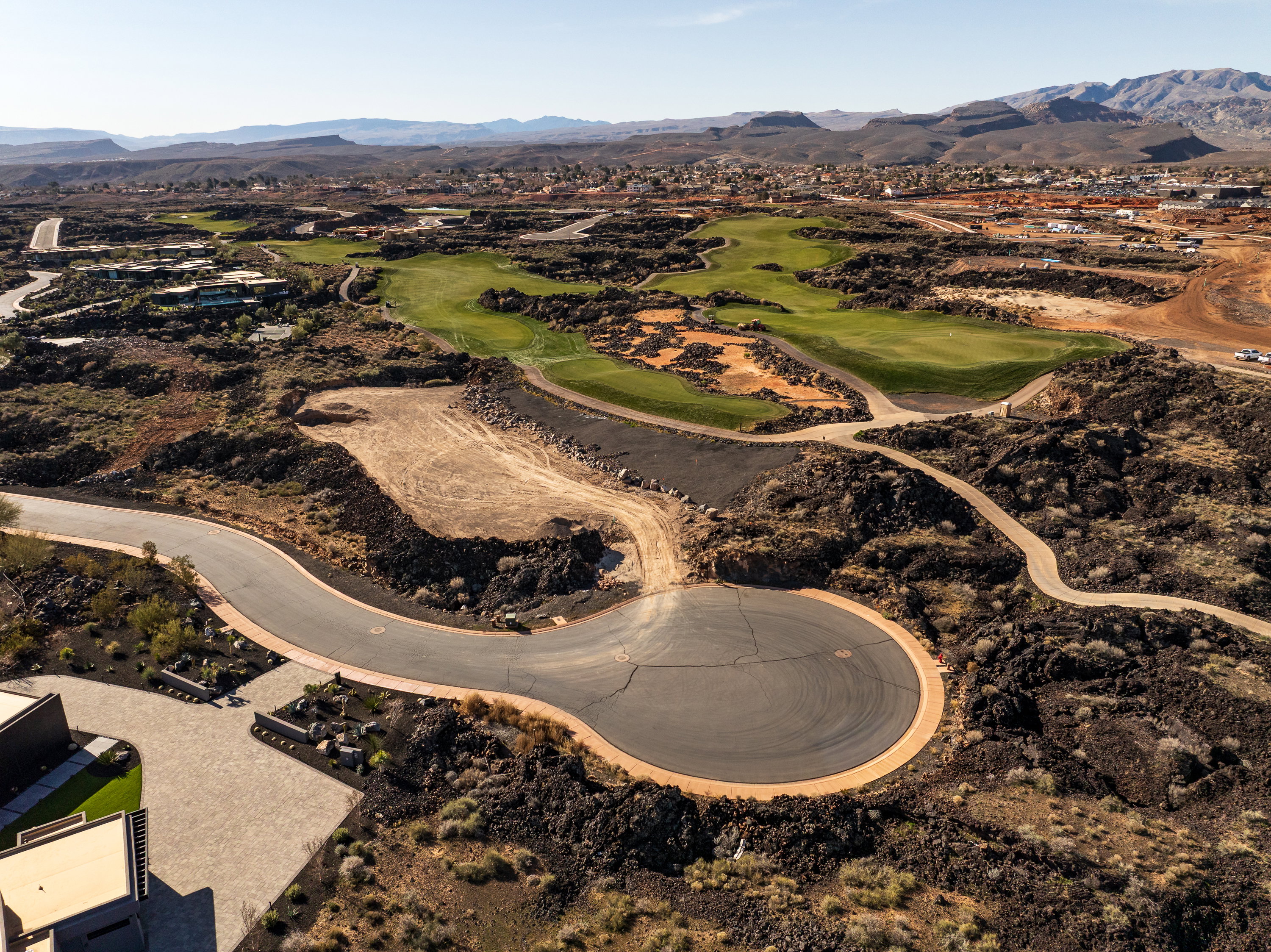 Aerial overview of property's location featuring a mountain backdrop and a golf club