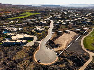 Aerial view of property and surrounding area featuring a mountainous background and a golf club