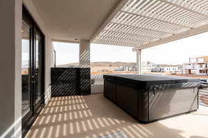 View of patio / terrace featuring a hot tub and a pergola