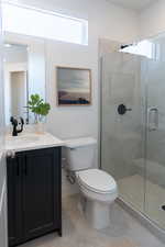 Bathroom with vanity, a stall shower, and light tile patterned floors