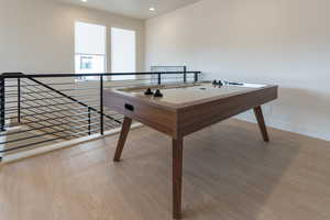 Rec room with light wood-style flooring and recessed lighting