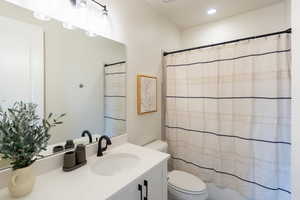 Full bathroom featuring vanity, shower / tub combo with curtain, and recessed lighting