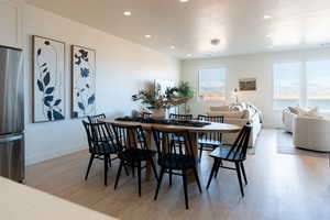 Dining room with light wood-type flooring and recessed lighting