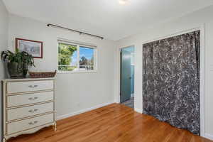 Main-floor ensuite bedroom with light hardwood flooring.