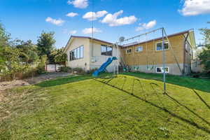 View of the fenced backyard with a heavy duty swingset, complete with automatic sprinkler system.