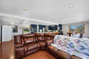 Great room featuring hardwood finished floors, beam ceiling, and recessed lighting - showcasing large gathering and formal dining area.