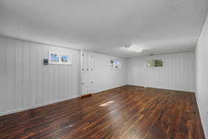 Daylight basement with dark wood-type flooring, bright paint and lighting.