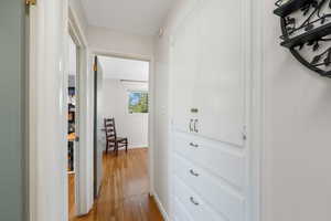Corridor featuring wood finished floors and built-in storage.
