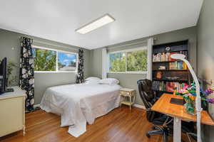 Main-floor bedroom with hardwood finished floors, bed size in this photo is a larger king bed.