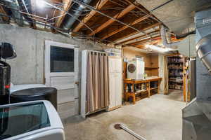 Daylight basement utility room with washer/dryer, water softener, and storage.