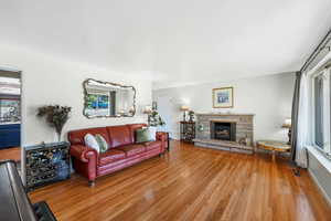 Front Living room featuring a fireplace, pocket door, light hardwood flooring, with ample natural light.
