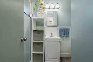 Main-floor ensuite half-bath with updated vanity and flooring.