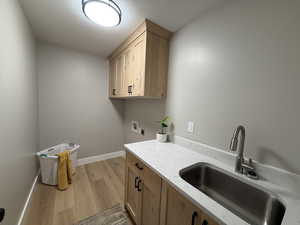 Laundry room featuring light wood-style floors, cabinet space, and hookup for a washing machine