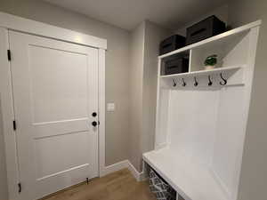 Mudroom with light wood-style flooring and baseboards