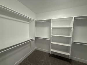 Walk in closet featuring dark carpet