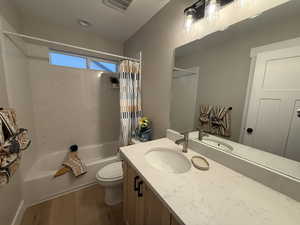 Full bathroom with shower / tub combo, wood finished floors, and vanity