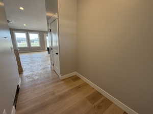 Corridor featuring light wood finished floors and recessed lighting