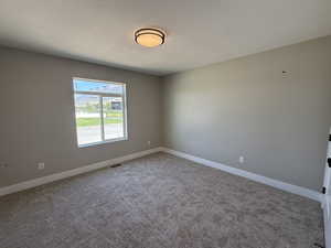 Empty room with a textured ceiling and carpet