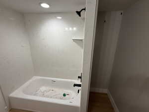 Full bath with bathing tub / shower combination and wood finished floors