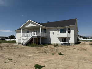 Back of house featuring stairs, a deck, stucco siding, and roof with shingles