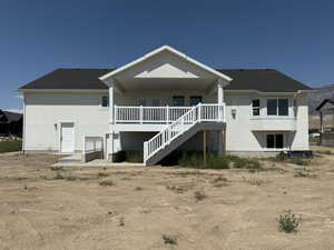 Rear view of property with stairway, a patio area, and stucco siding