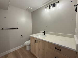 Bathroom with vanity, light wood finished floors, and a textured ceiling
