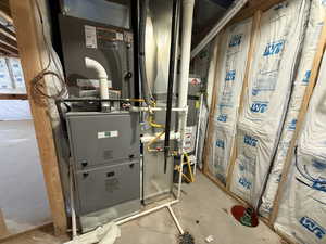Utility room featuring heating unit and water heater