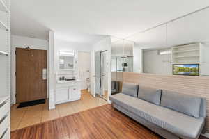 Full bath featuring light tile patterned floors, vanity, and tasteful backsplash