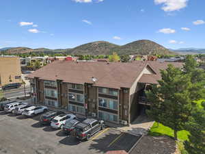 View of building exterior with uncovered parking, a mountain view, and a residential view