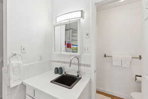 Half bath with vanity and tile walls