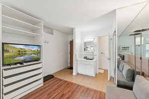 Living room with light tile patterned floors and a wall mounted air conditioner