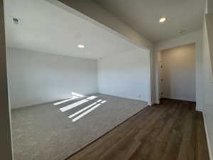 Spare room featuring recessed lighting, dark carpet, and dark wood-style flooring