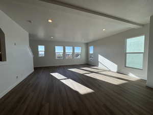 Unfurnished living room featuring a textured ceiling, dark wood-style floors, recessed lighting, and beam ceiling