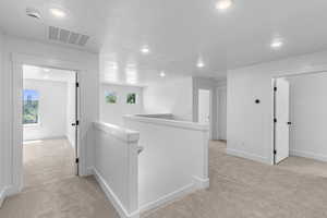 Hall featuring an upstairs landing, light colored carpet, and recessed lighting