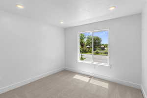 Carpeted spare room featuring baseboards and recessed lighting