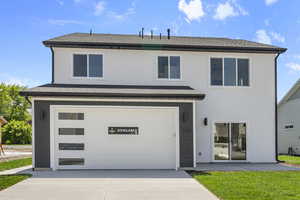 Traditional-style home featuring roof with shingles, concrete driveway, a garage, and stucco siding