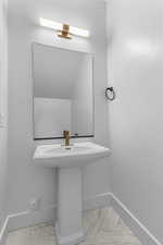 Bathroom with light marble finish flooring and baseboards