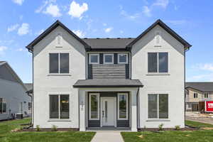 View of front facade featuring stucco siding and a front yard