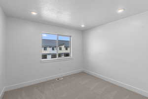 Spare room featuring carpet floors, recessed lighting, and a textured ceiling