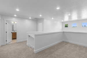 Basement with light colored carpet and recessed lighting