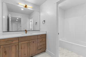Full bath with vanity, light marble finish floors, shower / bathtub combination, and recessed lighting