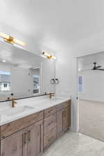 Bathroom with double vanity, light marble finish floors, and ceiling fan
