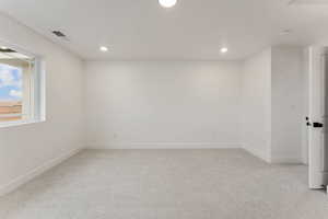 Unfurnished room featuring light carpet and recessed lighting
